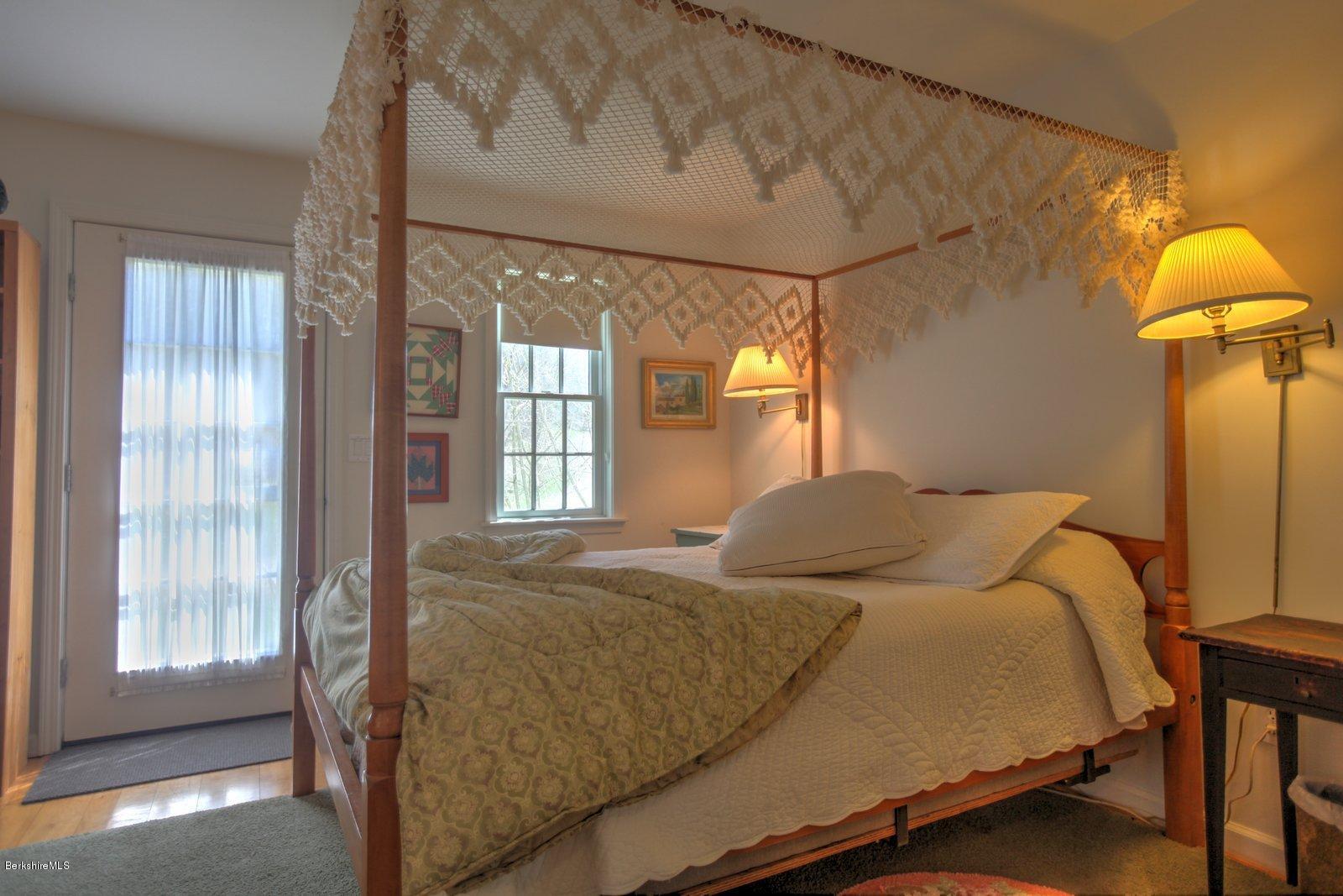 20 Main Road Tyringham, MA 01238 - Photo 29 of 50 a bedroom with a bed and a chandelier