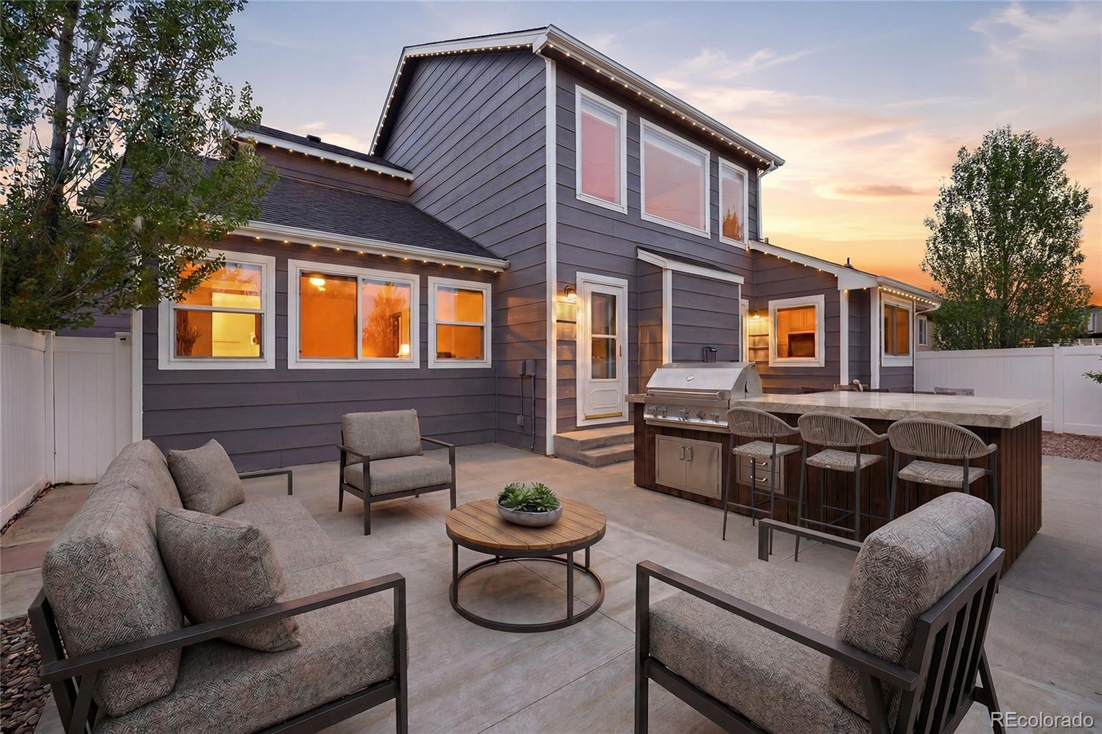 9288 Rockingham Drive Peyton, CO 80831 - Photo 44 of 49 a view of a patio with couches table and chairs with wooden fence