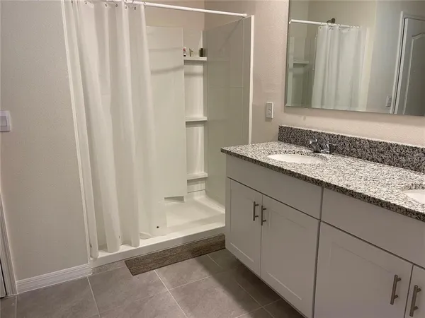 a bathroom with a granite countertop sink and a mirror
