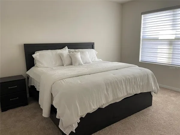 a bed sitting in a bedroom next to a window