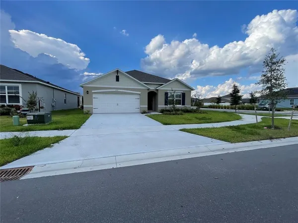 a view of a house with a big yard and large trees