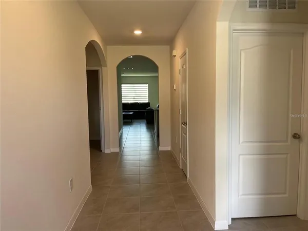 a view of a hallway with wooden floor and a closet