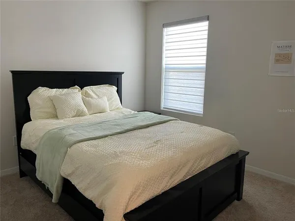 a large bed sitting in a bedroom next to a window