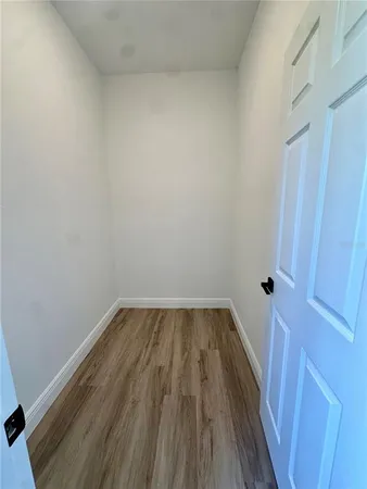 a view of a small space with wooden floor and a sink