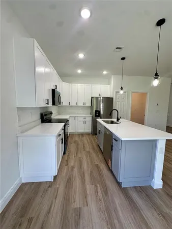 a large kitchen with stainless steel appliances sink a microwave and cabinets