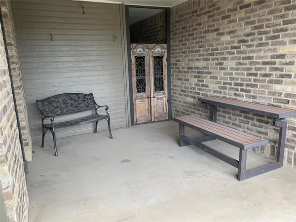 a bench sitting in a room next to a brick building
