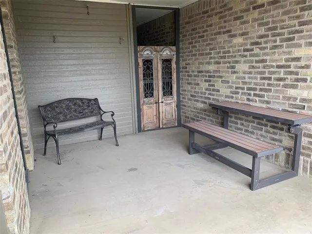 a bench sitting in a room next to a brick building