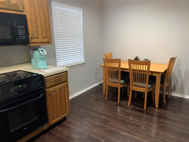 a kitchen with granite countertop wooden floors and a stove