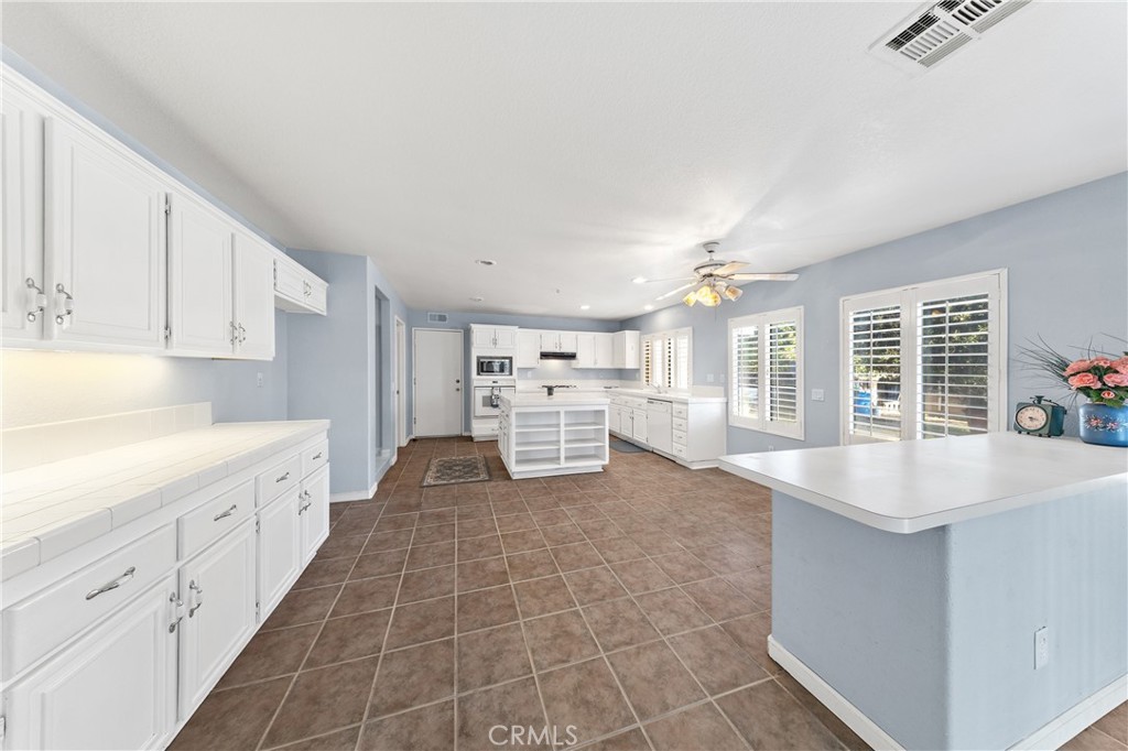32858 Alderbrook Road Wildomar, CA 92595 - Photo 13 of 56 a large white kitchen with cabinets