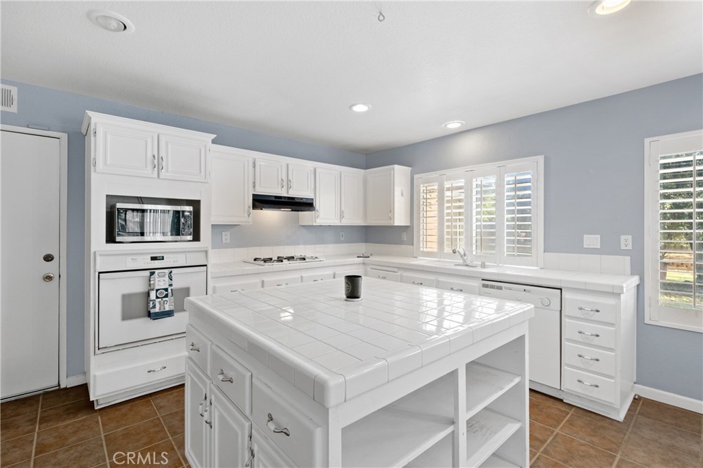 32858 Alderbrook Road Wildomar, CA 92595 - Photo 14 of 56 a kitchen with granite countertop a sink stove and cabinets