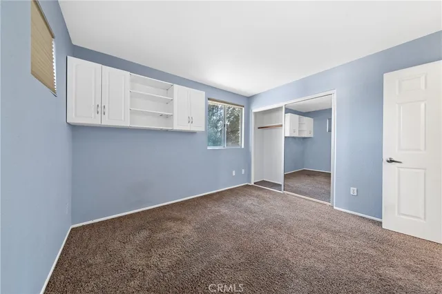 an empty room with windows and closet