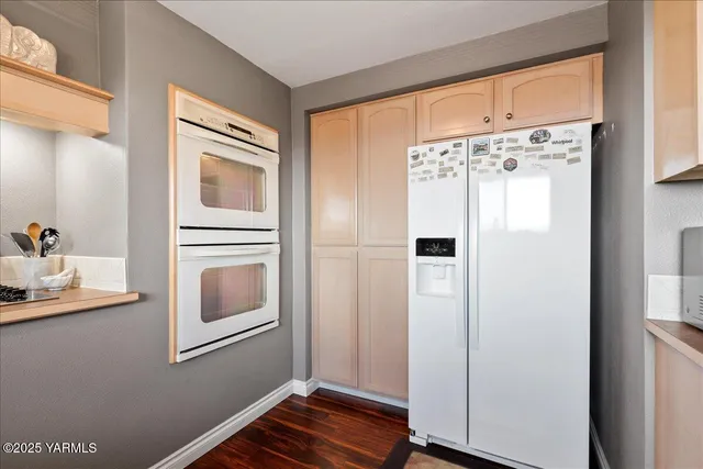 a dining room with stainless steel appliances furniture a fireplace and wooden floor