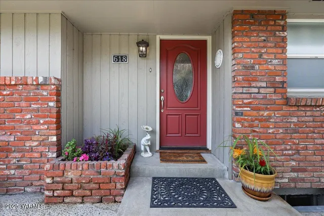 a view of a house with a yard and potted plants