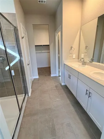 a bathroom with a granite countertop sink a mirror and a shower