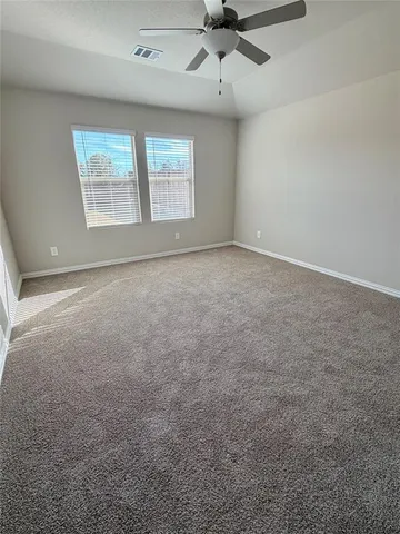 an empty room with a ceiling fan and window
