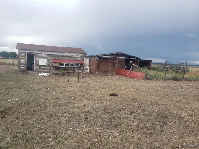 a view of a dry yard with wooden fence