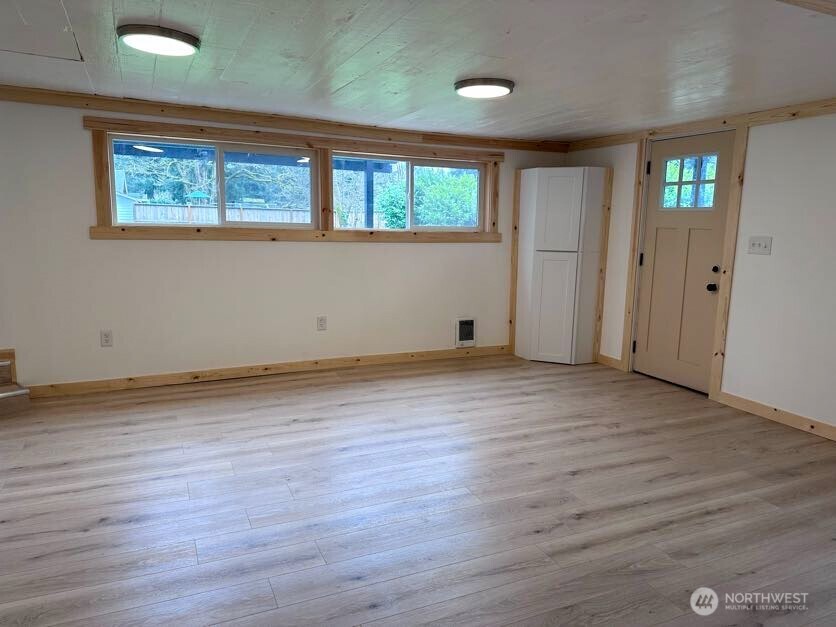 10341 184th Avenue Southwest Rochester, WA 98579 - Photo 27 of 36 a view of an empty room with wooden floor and a window