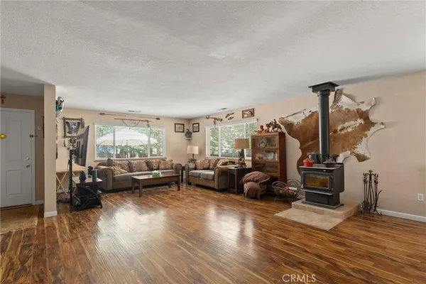 a living room with furniture a large window and a wooden floor