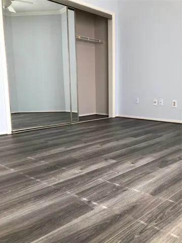 a view of a livingroom with an empty space & wooden floor