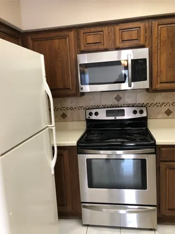 a kitchen with granite countertop a stove and a microwave