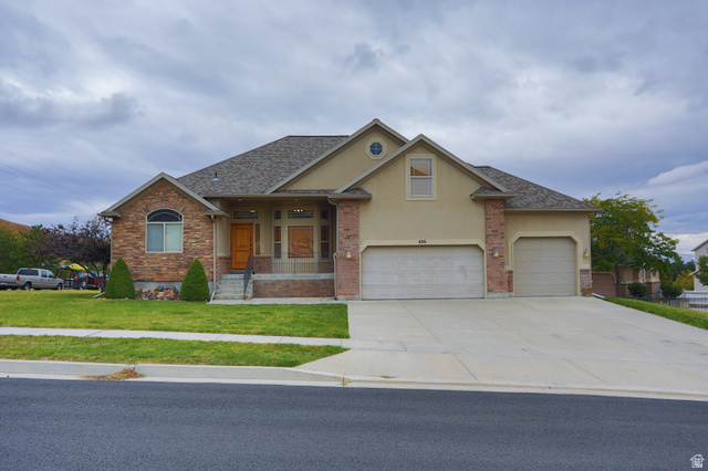 426 Deer Hollow Road Tooele, UT 84074 - Photo 28 of 37 Craftsman-style house featuring covered porch, a front yard, stucco siding, concrete driveway, and an attached garage