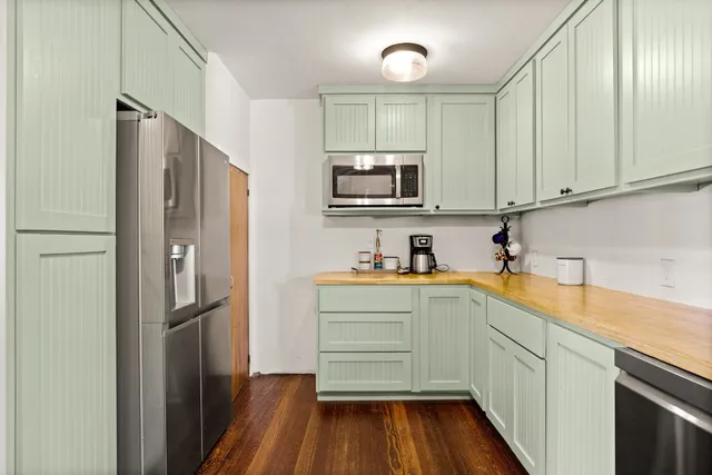 a kitchen with stainless steel appliances a refrigerator sink and microwave