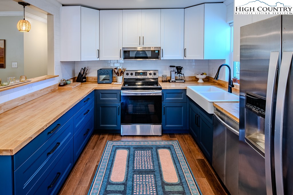 477 Hardaman Circle Boone, NC 28607 - Photo 14 of 48 a kitchen with stainless steel appliances granite countertop a stove a sink and a refrigerator