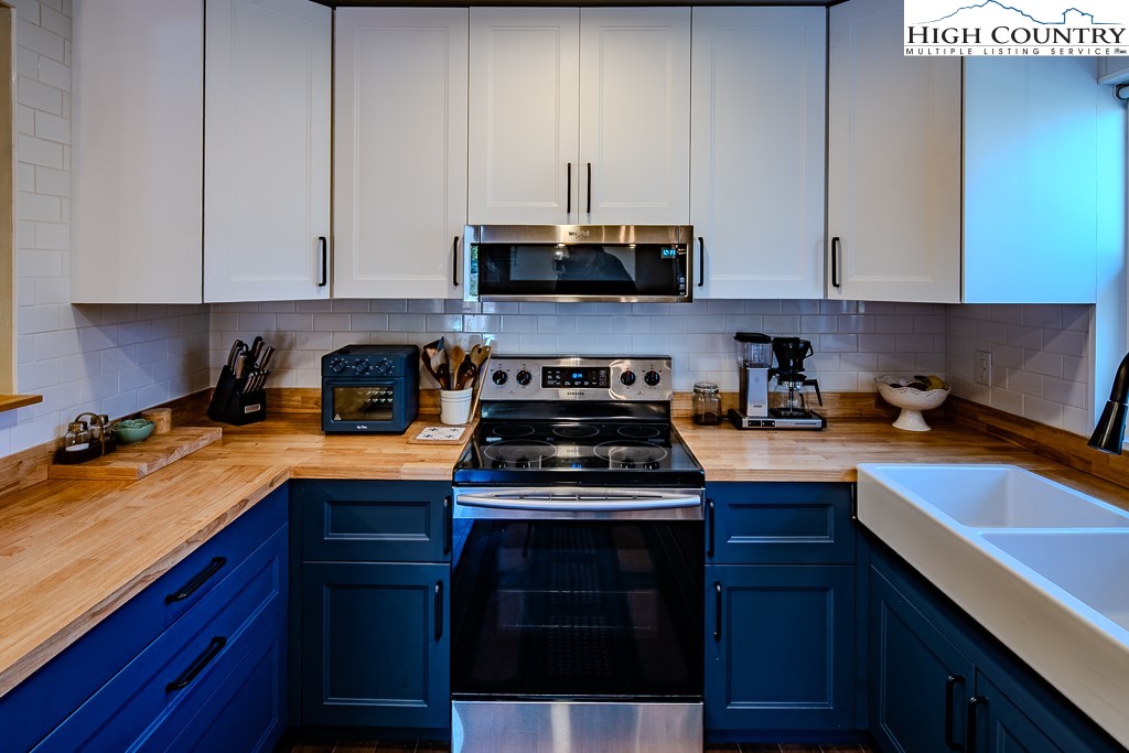 477 Hardaman Circle Boone, NC 28607 - Photo 16 of 48 a kitchen with stainless steel appliances granite countertop a sink a stove and a microwave