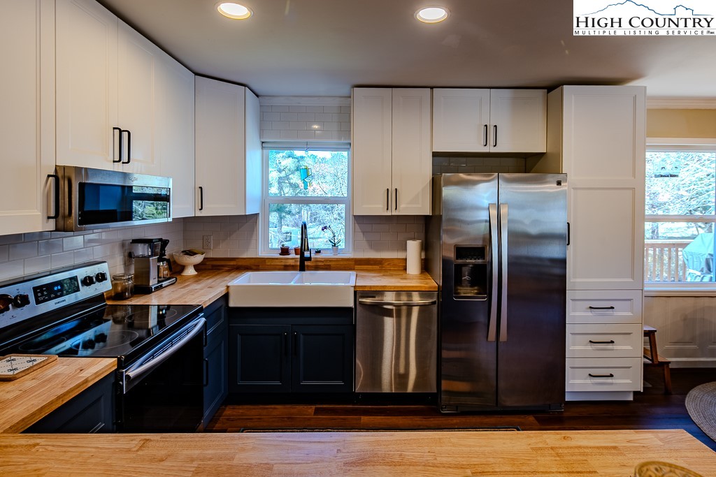 477 Hardaman Circle Boone, NC 28607 - Photo 17 of 48 a kitchen with stainless steel appliances granite countertop a refrigerator a sink dishwasher a stove and white countertops with wooden floor