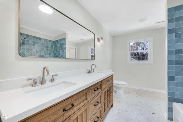 a bathroom with a double vanity sink and a mirror