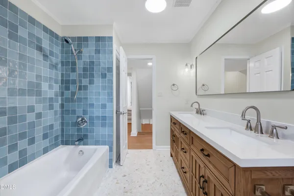 a bathroom with a double vanity sink a mirror and a bathtub