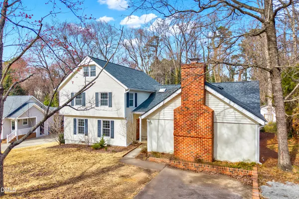 a view of a white house with a yard and large tree