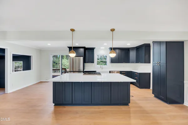 a kitchen with a sink a counter space and wooden floor