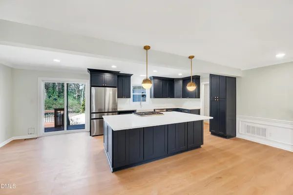 a kitchen with kitchen island a sink stove and refrigerator