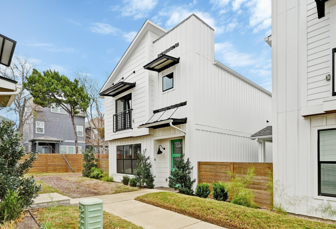 View of front of property featuring board and batten siding and a balcony