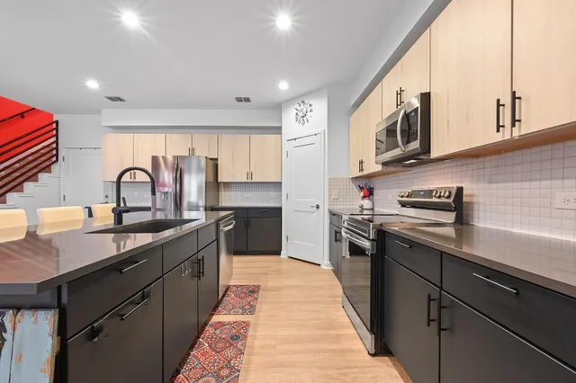 a kitchen with stainless steel appliances granite countertop a sink stove microwave and cabinets