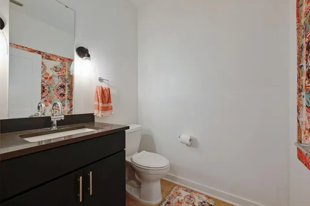 a bathroom with a granite countertop toilet sink and mirror