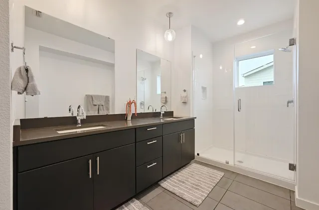 a bathroom with double sink and a mirror