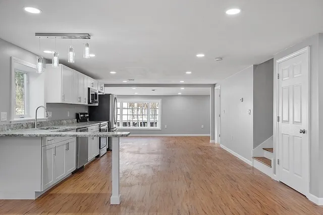 a large kitchen with cabinets and wooden floor