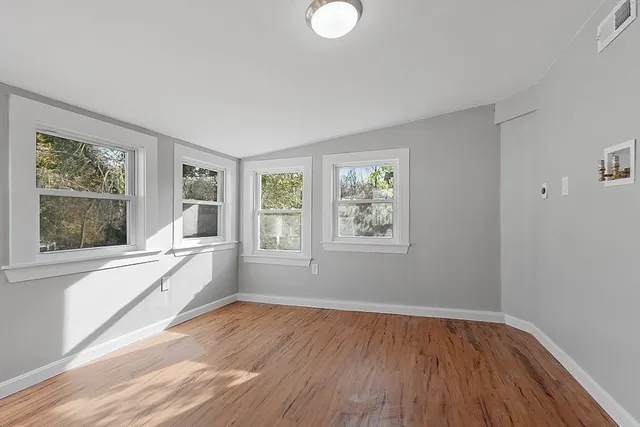 a view of a room with wooden floor and windows