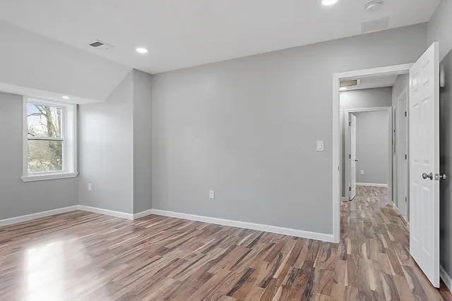 a view of a room with wooden floor and windows