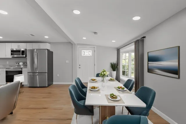 a view of a dining room with furniture a kitchen and chandelier