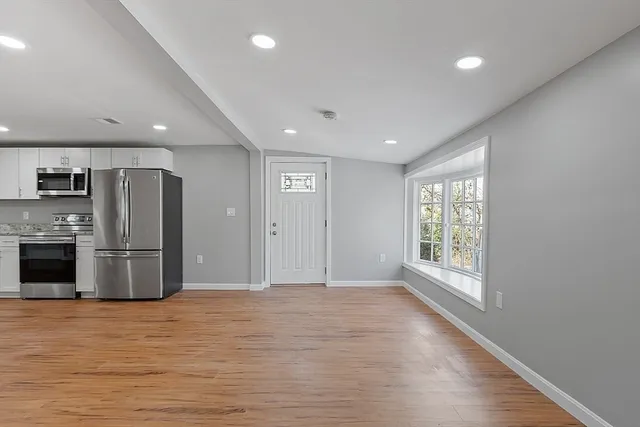 a view of a kitchen with stainless steel appliances a refrigerator and a stove top oven