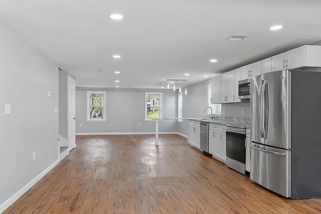 a view of kitchen with refrigerator microwave and wooden floor
