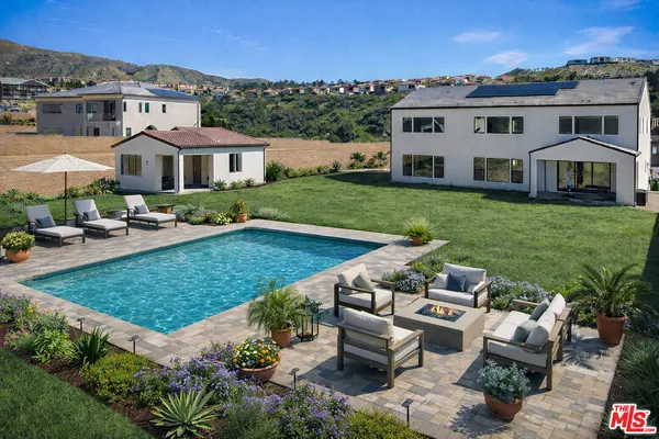an aerial view of a house with swimming pool garden and patio