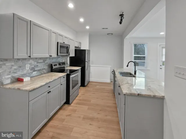 a kitchen with stainless steel appliances granite countertop a sink and cabinets