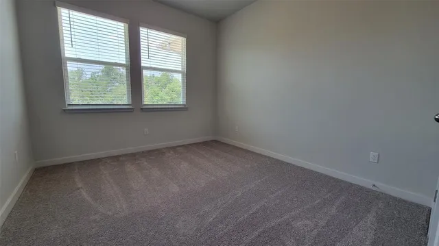 an empty room with fan and windows