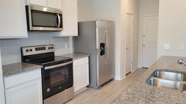 a view of kitchen with wooden floor and electronic appliances