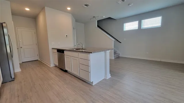 a view of a kitchen with wooden floor and electronic appliances