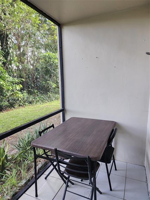 8020 Fairview Drive, Unit 109 Tamarac, FL 33321 - Photo 6 of 12 a view of a room with a table and chairs in it